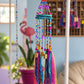 Full-length handmade boho mobile with turquoise frame, colorful beaded strands and textile tassels in an eclectic room.