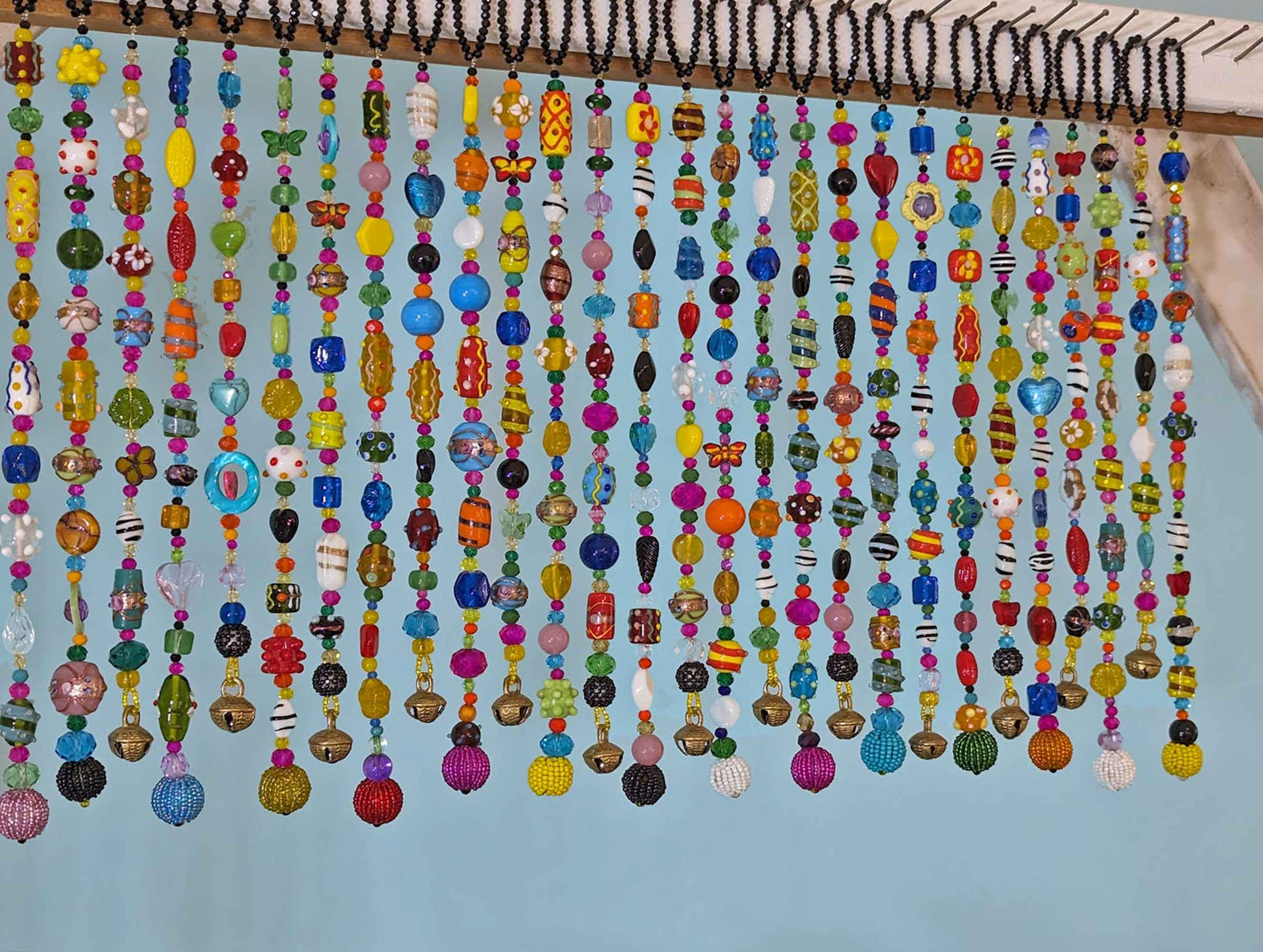 close up colorful lampwork glass beads on handmade beaded curtain