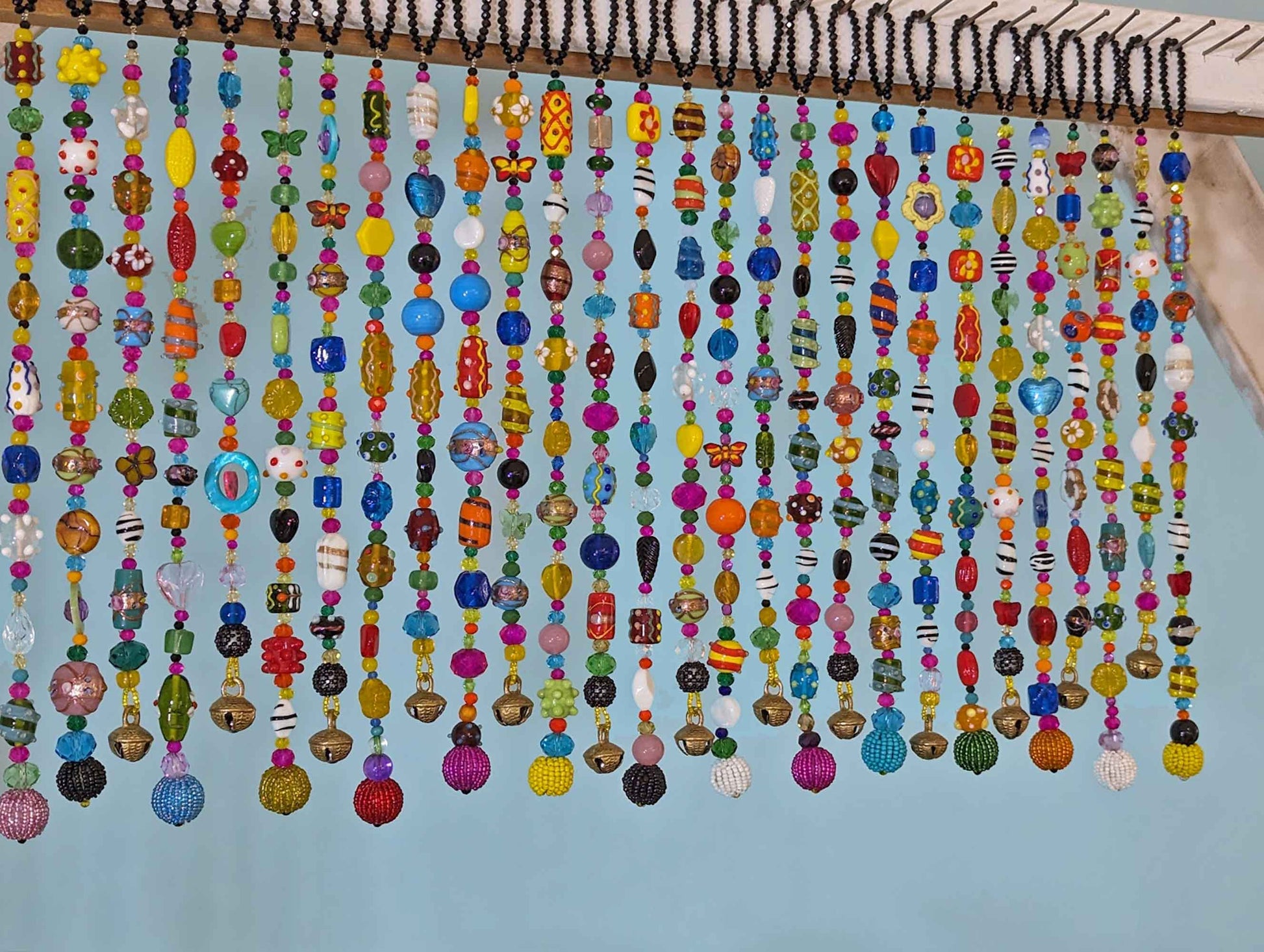 close up colorful lampwork glass beads on handmade beaded curtain