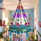 Detailed view of turquoise circular mobile frame with purple, pink and blue glass beads and decorative trim.