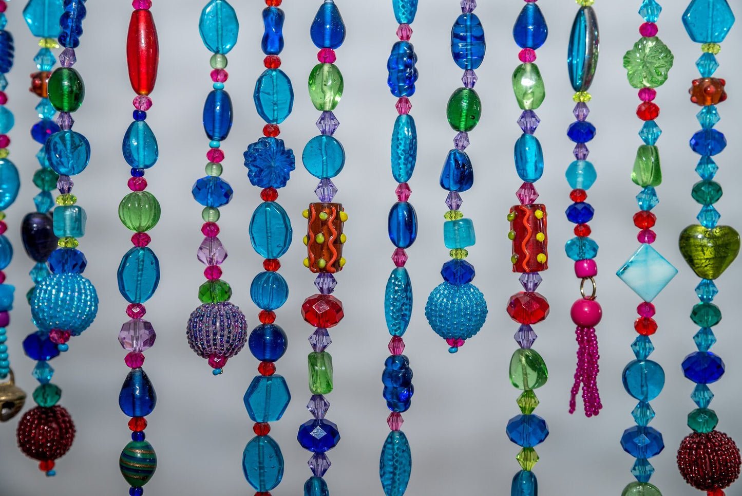 Unique Handmade Beaded curtain Arch Shape in Shadows of Blue, Turquoise, Green, Purple, Red, and Fuchsia.